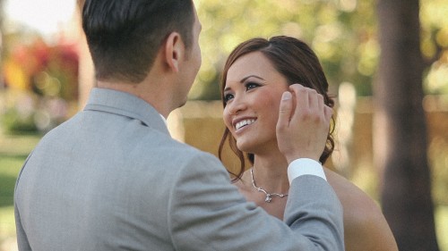 Groom brushes bak brides hair