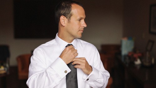 Groom adjusting tie