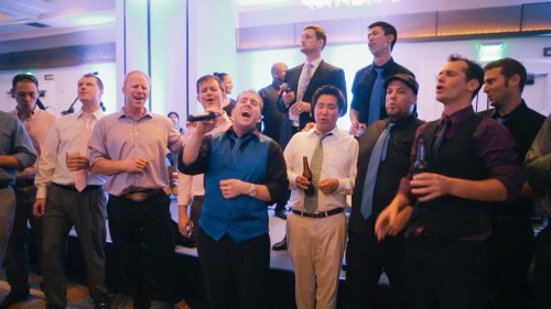 Groom sings with acapella group at wedding