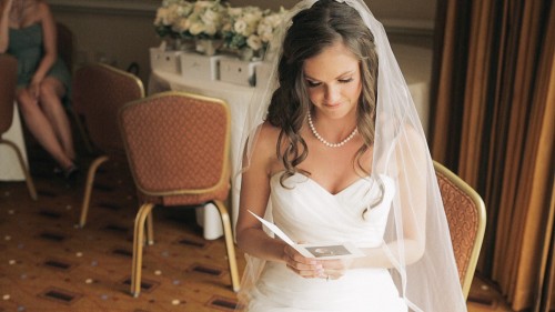 Bride reading letter from groom before wedding ceremony.