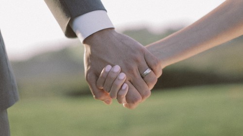 Bride and groom hold hands