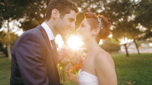 Bride and groom kiss in sunset