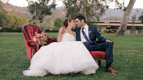 Bride and groom on couch outside