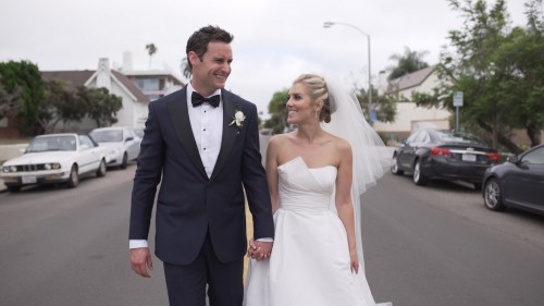 Bride and groom walk down street la jolla