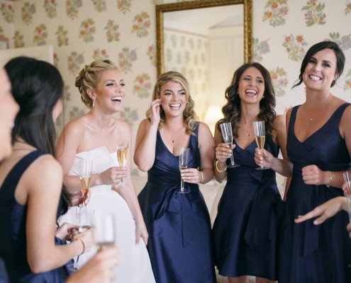 Bride and bridesmaids laughing toast Darlington house