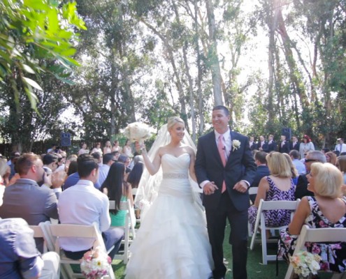 Bride and groom walk down the ailse at Twin Oaks Garden Estate