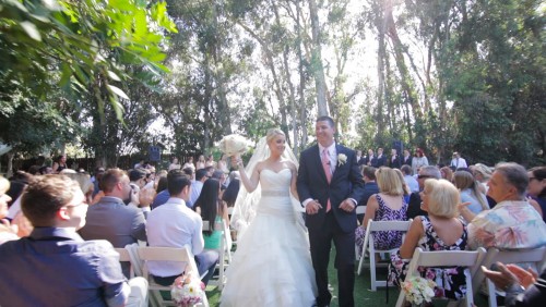 Bride and groom walk down the ailse at Twin Oaks Garden Estate