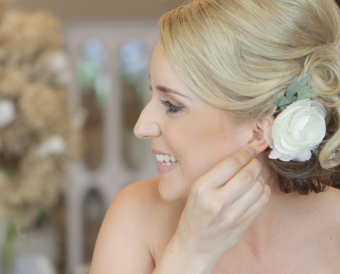 Bride putting in ear ring in San Diego Wedding Video at Twin Oaks Gardens and Estate