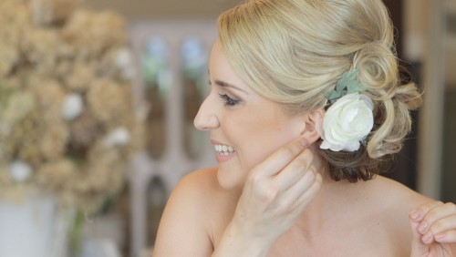 Bride putting in ear ring in San Diego Wedding Video at Twin Oaks Gardens and Estate