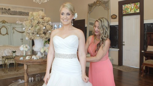 Bride putting on wedding dress San Diego Wedding Video at Twin Oaks Gardens and Estate