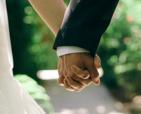 bride and groom hold hands at wedding video