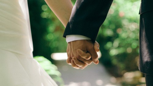 close up of bride and groom holding hands