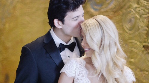 Bride and groom in front of golden wall