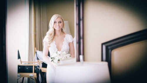 Bride looking in mirror before ceremony.