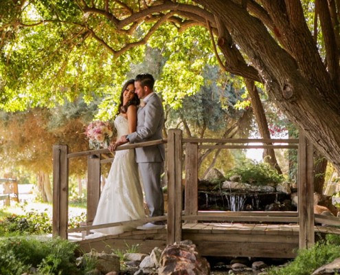 Bride and groom on bridge at Lake Oak Meadows in Temecula wedding video.