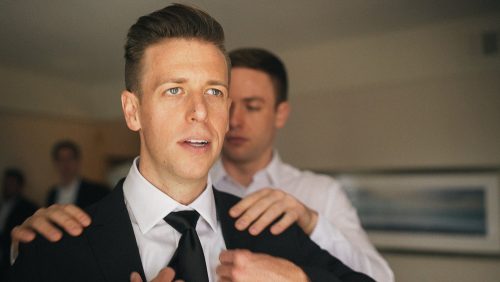 Groom getting ready put on jacket