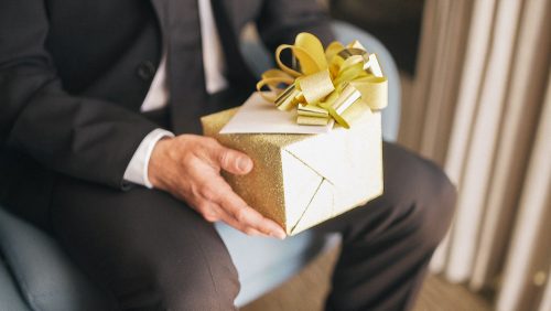 Groom holds gift before wedding