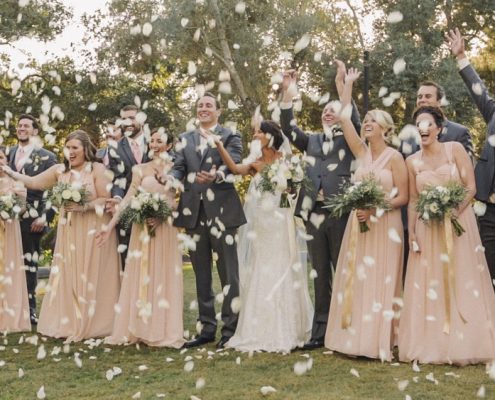 Bridal party throw flower petals at Mt Woodson Castle