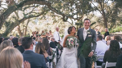 Bride and groom walk down the ailse. 
