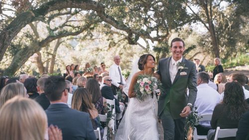 Bride and groom walk down the ailse. 