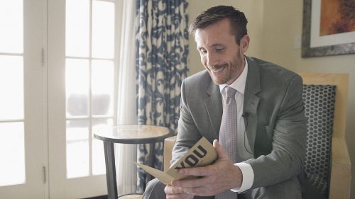 Groom reads card before wedding