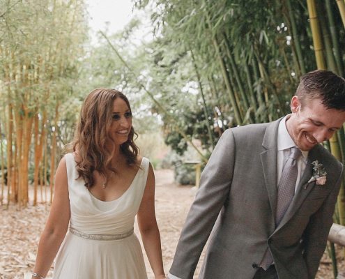 Bride and groom walk near bamboo