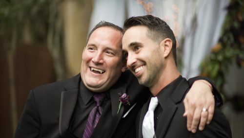 Groom with best man vampire teeth