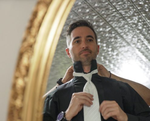 groom getting ready in mirror