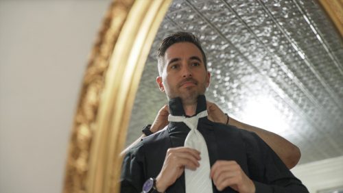 groom getting ready in mirror