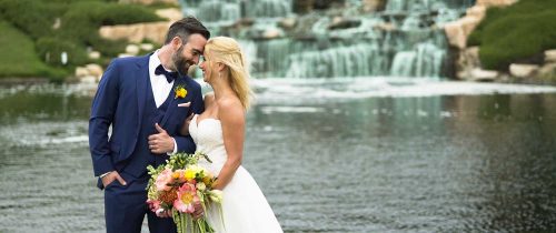 Bride and groom in front of waterfall at crossings at carlsbad wedding