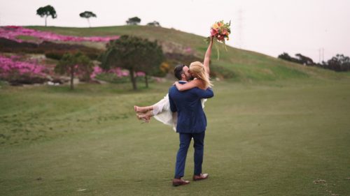 Crossings at Carlsbad wedding bride hold bouquet in the air on golf course