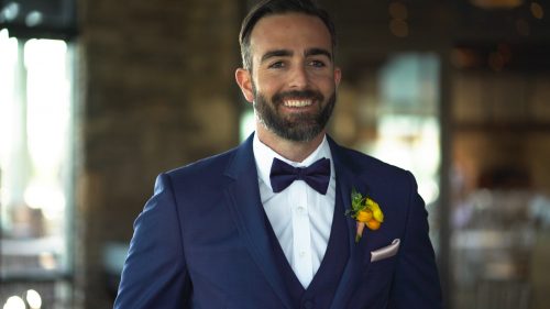 Crossings at Carlsbad wedding Groom putting on jacket and smiling