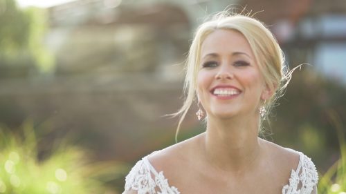 Beautiful Bride posing for portraits in sunlight for wedding video 