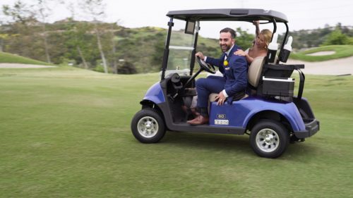 Bride and groom in golf cart 