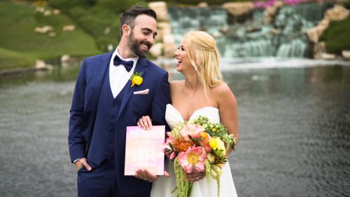 Bride and groom hold wedding sign