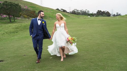 Bride and groom hold hands after wedding 