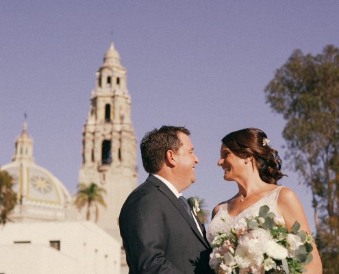 bride and groom with he tower of the Museum of Man in Balboa Park in the background