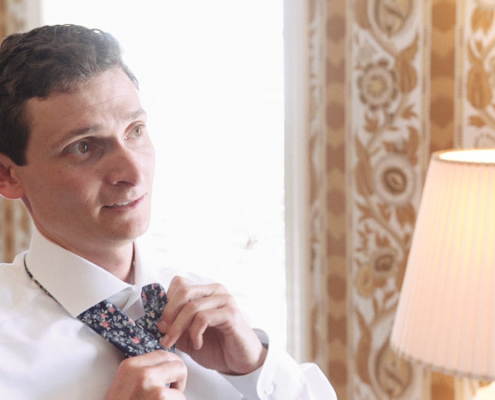 Groom fixes his tie before wedding