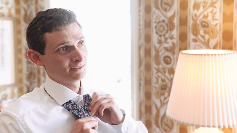 Groom fixes his tie before wedding