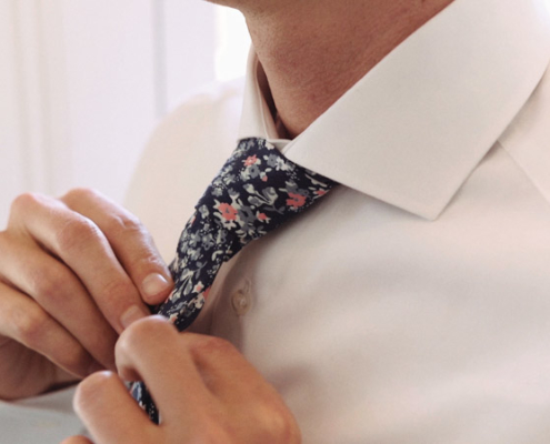 Groom fixes his tie before wedding