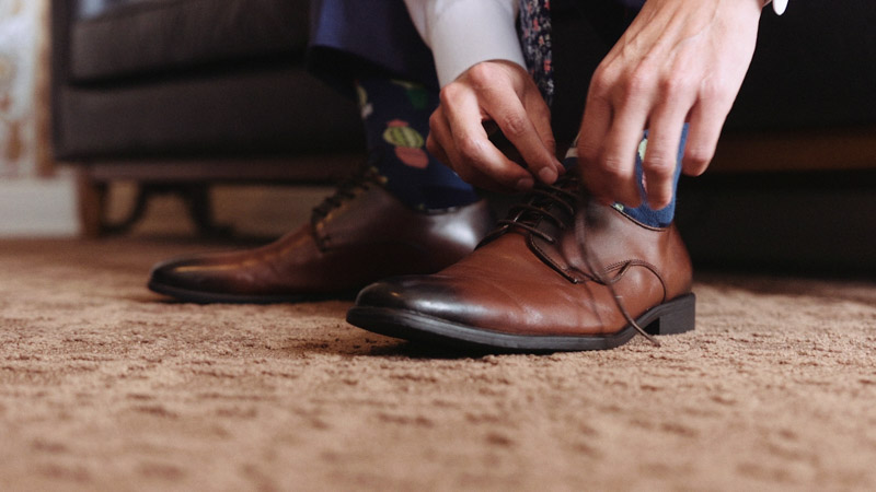 Groom tying his shoes before wedding