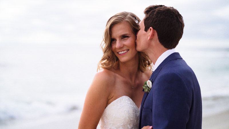 Groom kisses bride on the cheek on the beach at La Jolla Cove Wedding Video
