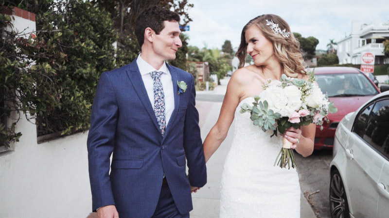 Bride and groom walk on street in La Jolla