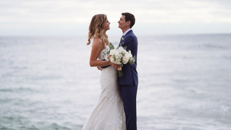 Bride and groom stand in front of ocean La Jolla Cove Wedding Video