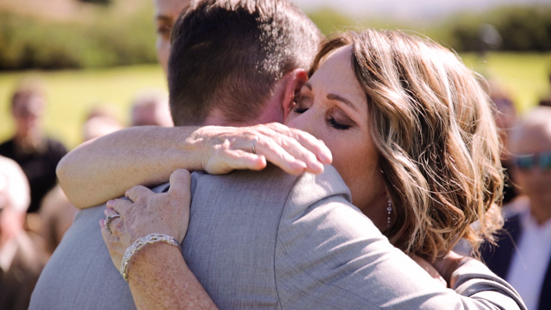 Mom hugs groom at wedding