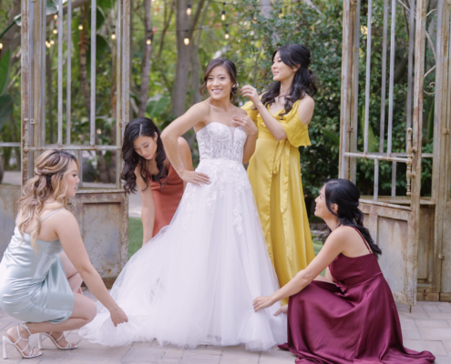 Bride with bridesmaids putting on wedding dress at Botinca Trademark Venue